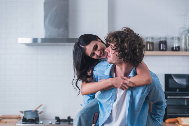 abbracciare e divertirsi insieme una giovane coppia felice coccole a casa loro - Foto, immagini