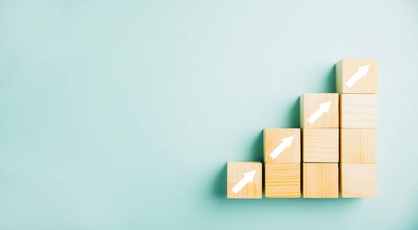Ladder career path symbolizing business growth and success. Wooden blocks arranged as step stairs with an upward arrow. Progressing towards higher revenue, goals finance, investment strategies - Photo, Image