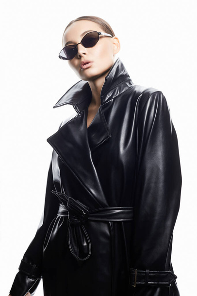fashion portrait of Beautiful woman in sunglasses and leather trench coat. beauty girl in trendy Glasses - Foto, Imagem
