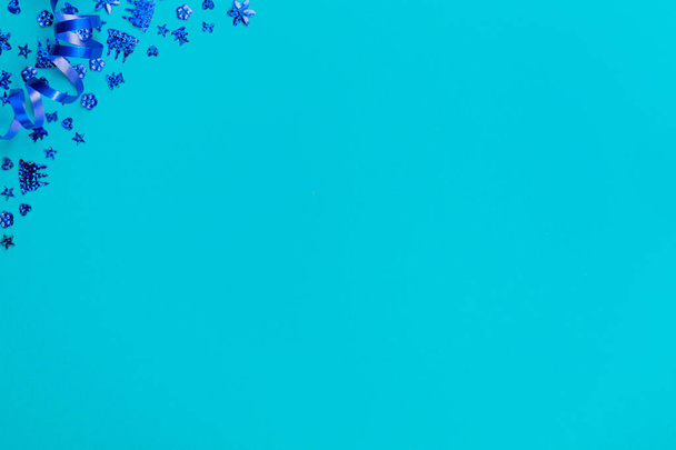 Kék háttér a születésnapi party kék serpentine és konfetti. Jelen van a fénymásolási hely. Felülnézet. - Fotó, kép