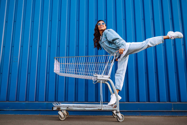 Selfie time. Young woman having fun on shopping trolleys. Black friday. Consumerism, sale, discounts, lifestyle concept. - Foto, Imagen