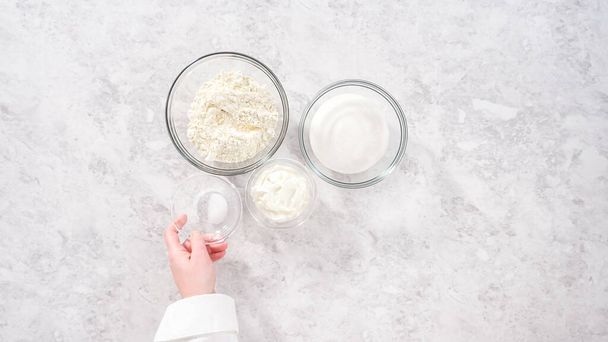 Flat lay. Step by step. Ingredients in glass mixing bowls to bake funfettti bundt cake. - Foto, afbeelding
