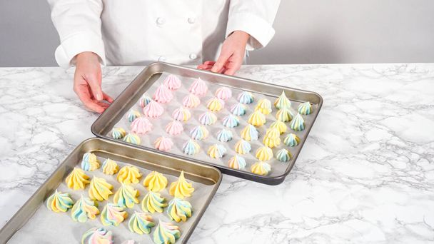 Step by step. Piping unicorn meringue cookies to the baking sheet lined with a parchment paper. - Photo, Image