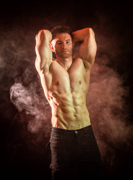 Handsome male bodybuilder in studio shot, with dramatic lighting, wearing briefs, - Foto, Imagen