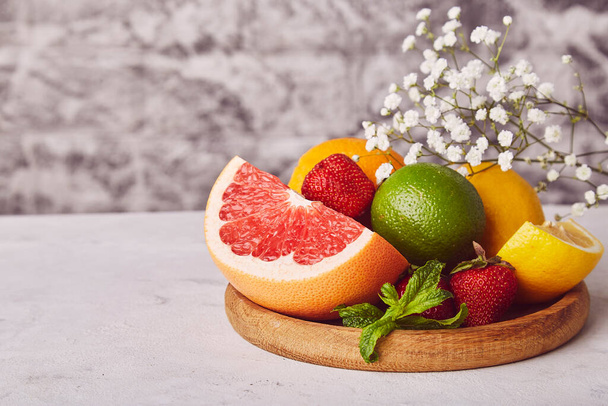 Healthy wooden plate with fresh citrus. Organic, natural vitamins background. Copy space. - Photo, Image