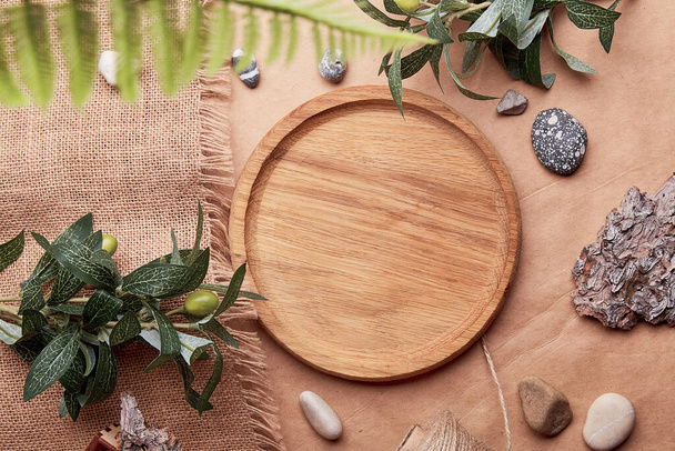  Mock up, template wooden plate among brown and golden sustainable products. Natural tree bark, golden leaves, pebbles on crafting paper. - Photo, Image