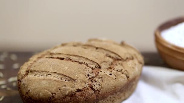 Tuore leivottu leipä kotitekoista orgaanista hapantaikinan ruisleipää puupöydällä
 - Materiaali, video
