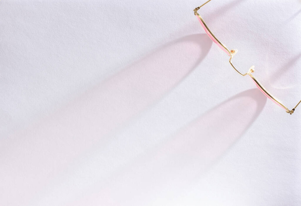 Вид зверху на рожеві сонцезахисні окуляри на білому тлі з сонячним світлим відтінком з копією простору
. - Фото, зображення