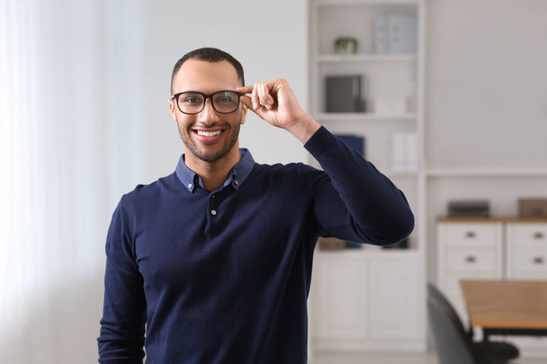 Smiling young businessman with eyeglasses in modern office - Φωτογραφία, εικόνα
