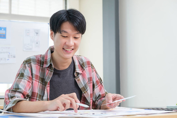 Молодой азиат UX дизайнер планировщик разработки приложений, набросок шаблона макета в офисе. - Фото, изображение