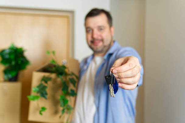 Couple showing keys to new apartment. real estate mortgage, loan concept. moving in new house. Young smiling couple holding their new house keys. first own apartment or house. - Fotoğraf, Görsel