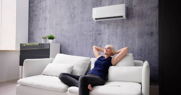 Happy Young Woman Relaxing Under The Air Conditioner - Foto, Imagem