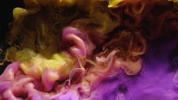 Una inyección de agua de tinta. Nube de humo de color. Mezcla de fluidos. Amarillo rosa púrpura pintura brillante mezcla salpicaduras partículas de polvo de purpurina sobre fondo abstracto negro oscuro arte. - Foto, imagen
