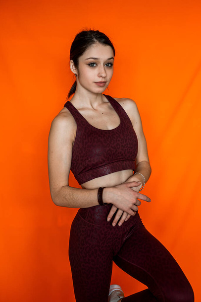 Portrait of slim woman wear sport cloth isolated on orange background. Sport healthy lifestyle - Photo, Image