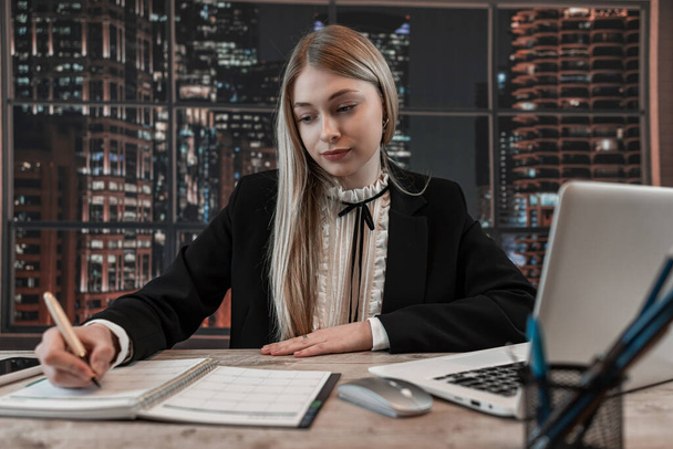 Jeune femme d'affaires travaillant avec ordinateur et écrire dans ntepad dans le bureau. Femme consultante gestionnaire employée à l'emploi.  - Photo, image