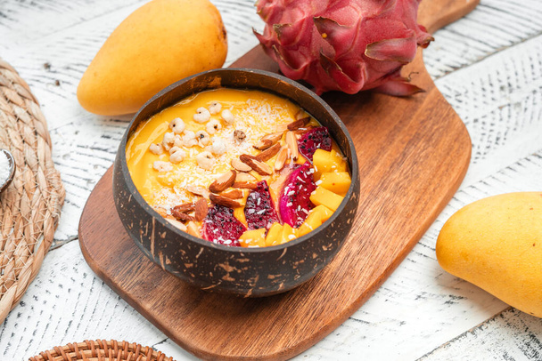 Mango Fruit Smoothie Bowl in kokosnoot Shell Cup, witte achtergrond - Foto, afbeelding