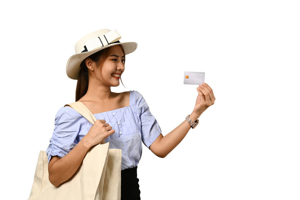 Портрет усміхненої молодої жінки-туристки, що показує кредитну картку ізольовано на білому тлі
. - Фото, зображення