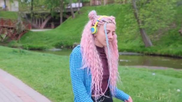 a girl with pink hair is dancing merrily on the street. - Footage, Video