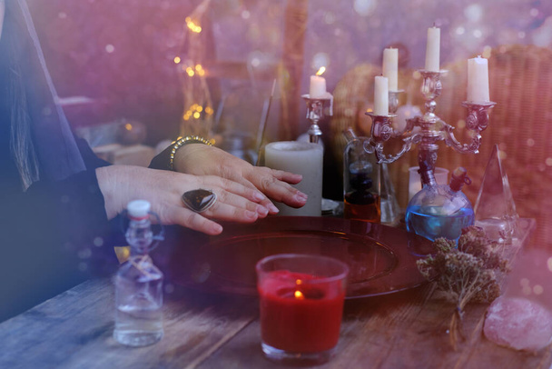 ed dish with water, candle lights in dark room of future fortuneteller, esoteric Oracle, session of magic, divination for the future, activity at halloween party, prophecies from the world of spirits - Valokuva, kuva