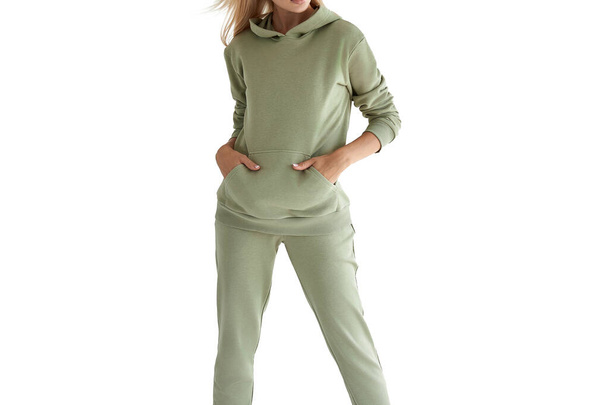Menina usa capuz verde claro e calças. estúdio filmado para venda de roupas esportivas. camuflagem mock-up - Foto, Imagem