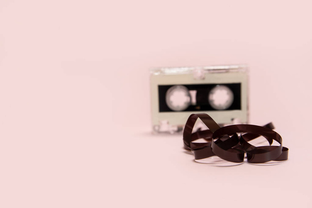 Cassetta audio con nastro tirato fuori su uno sfondo rosa - Foto, immagini