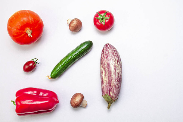 Creative layout of zucchini, bell peppers, sherry tomatoes, tomatoes, cucumbers and mushrooms on a white background. Food concept. Healthy food. View from above. Copy space. - 写真・画像