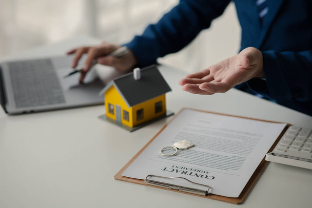 Ev ve emlakçılar, ev modelli ev satıcıları ve konut projelerinin ev satın alma sözleşmesi belgeleri, gayrimenkul hakkında ayrıntılı bilgi sağlıyorlar. Gayrimenkul ticareti. - Fotoğraf, Görsel