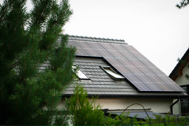 Techo de casa con módulos fotovoltaicos. Casa de campo histórica con paneles solares modernos en el techo y la pared Foto de alta calidad - Foto, Imagen