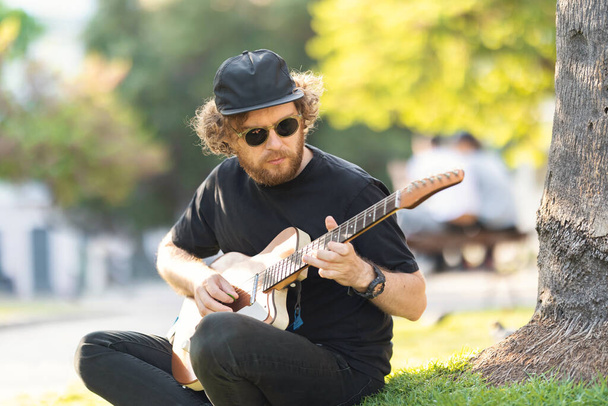 Hombre tocando la guitarra en la calle. Mid shot - Foto, Imagen