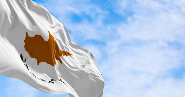 Kyperská národní vlajka vlaje ve větru za jasného dne. Bílá se siluetou měděně oranžového ostrova a dvěma zelenými olivovými větvemi pod ní. 3D ilustrace vykreslení. Třpytivá textilie - Fotografie, Obrázek