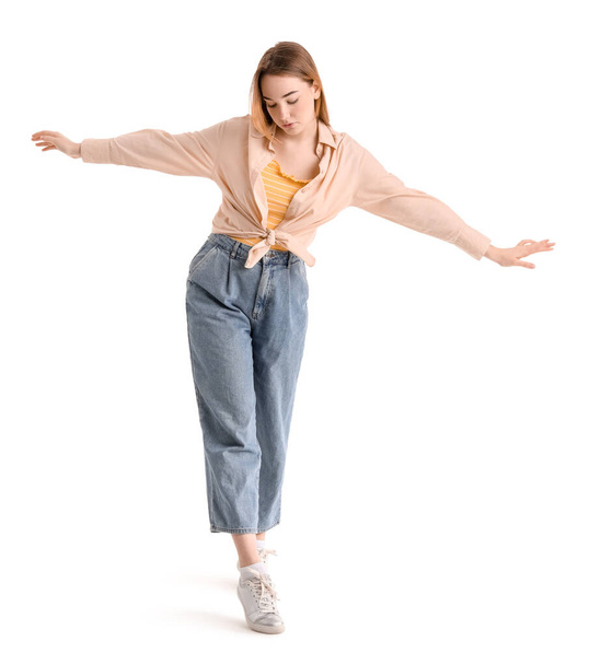 jonge vrouw balanceren op witte achtergrond - Foto, afbeelding