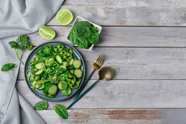 Tányér saláta zöld zöldség szürke fa háttér - Fotó, kép