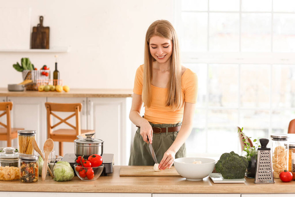 Молодая женщина режет грибы для макарон на кухне - Фото, изображение
