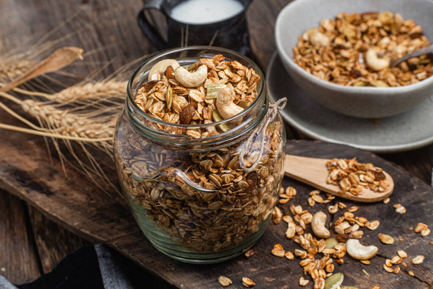 Granola with nuts, raisins and pumpkin seeds in a glass jar - Fotografie, Obrázek