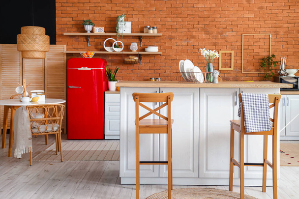 Interior de la cocina con nevera roja, mostradores, estantes y sillas - Foto, Imagen