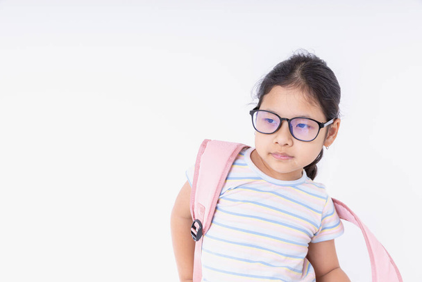 Азиатские дети девушки в очках с розовыми рюкзаками учатся в школе изолированы на белом фоне с копировальным пространством. Конфликты возвращаются в школу, учебу, образование. - Фото, изображение