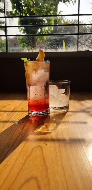 Verres transparents avec boissons sucrées à l'intérieur avec boisson colorée, avec ombre et fond de table avec glaçons sur un bar restaurant - Photo, image