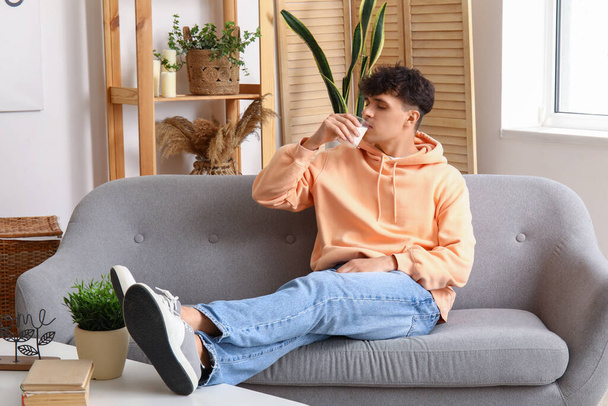 Young man drinking milk at home - Zdjęcie, obraz