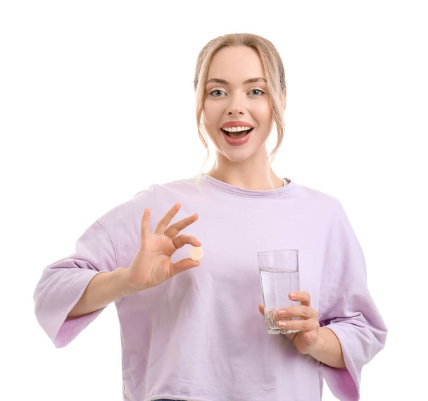 Young woman with soluble tablet and glass of water on white background - Valokuva, kuva