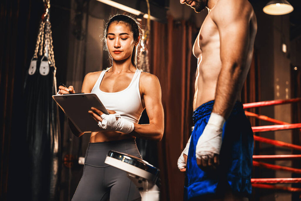 Muay Thai boxeador paso en la escala de peso para la designación de la clase de boxeo por medición de peso antes del combate de boxeo. Atleta dedicado fitness y boxeadores físicos preparación corporal. Impulso - Foto, imagen