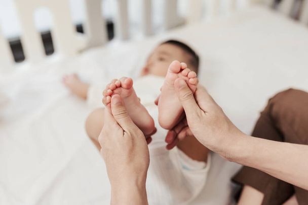 Selektiver Fokus, Baby-Fußmassage zur Förderung der Entwicklung der Mutter. Mutter macht Massage für glückliches Baby. Gesundheitskonzept für Kleinkinder. - Foto, Bild