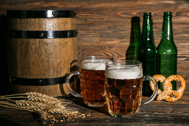 Mokken koud bier op houten ondergrond. Oktoberfeest viering - Foto, afbeelding