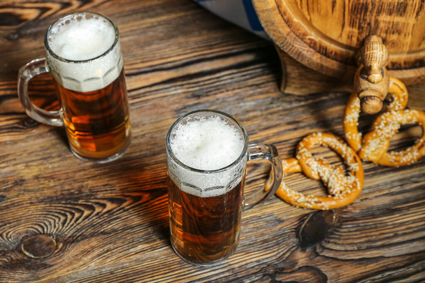 木製の背景に冷たいビールのマグカップ。オクトーバーフェストお祝い - 写真・画像
