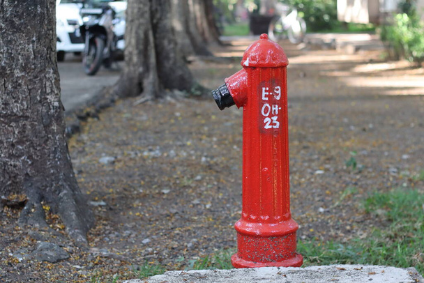 Fire hydrant, fireplug, or firecock on a street side. It is a connection point by which firefighters can tap into a water supply. It is an essential component of active fire protection - Photo, Image