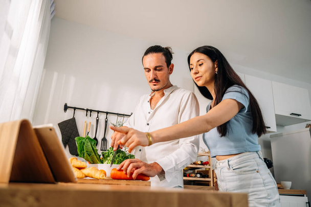 Healthy lovers cooking food in kitchen, Happy young couple spending time together at home, Husband and wife relaxing and resting at modern house, Family and lovers with hobby lifestyle - Photo, Image