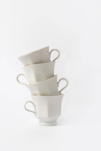 White coffee cups and saucers with a gold brim on white background. Top view. - Zdjęcie, obraz