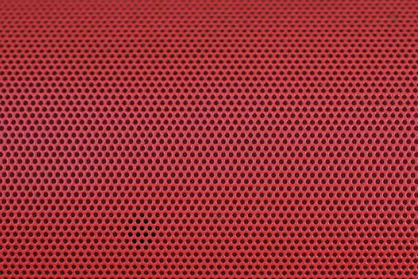 textura de una rejilla de metal frente a un altavoz de música roja - Foto, imagen