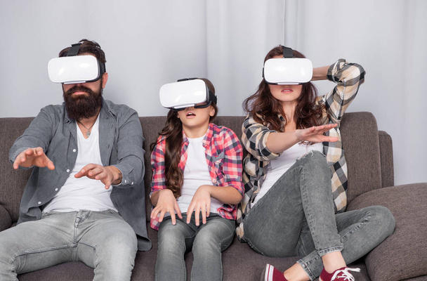 mom dad and daughter. digital future and innovation. modern life. father mother and child wireless VR glasses. virtual reality family. parents with kid girl use modern technology. - Fotoğraf, Görsel