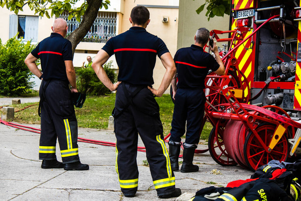 Tűzoltók a franciaországi Reimsben, tűz alatt álló épületben - 2023. június 26. A tűzoltók azon dolgoznak, hogy eloltsanak egy tüzet, ami a franciaországi Croix Rouge körzet egyik épületében tört ki..  - Fotó, kép
