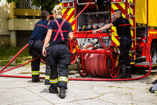 Feuerwehrleute bei einem Einsatz in einem brennenden Gebäude in Reims, Frankreich - 26. Juni 2023 Feuerwehrleute arbeiten daran, ein Feuer zu löschen, das in einem Gebäude im Croix Rouge Distrikt von Reims in Frankreich ausgebrochen ist.  - Foto, Bild
